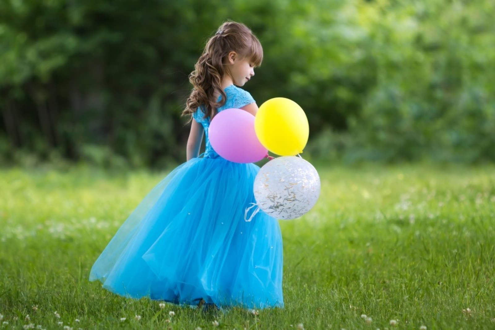 dievcatko v modrych satach s farebnymi balonmi